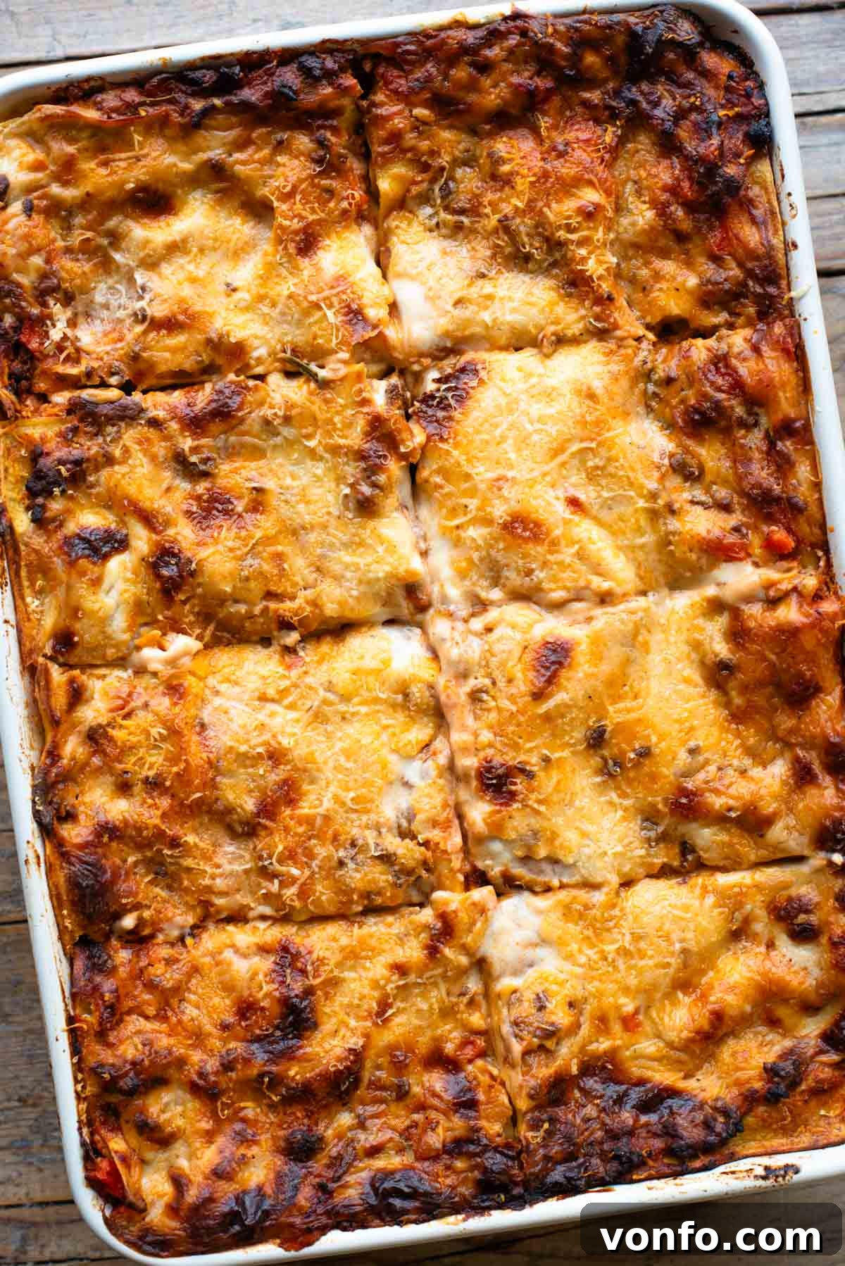 Hearty Lamb Lasagna with Pecorino Romano Béchamel 14 An overhead shot of a baked lamb lasagna in a large baking dish, perfectly cut into 8 individual pieces.