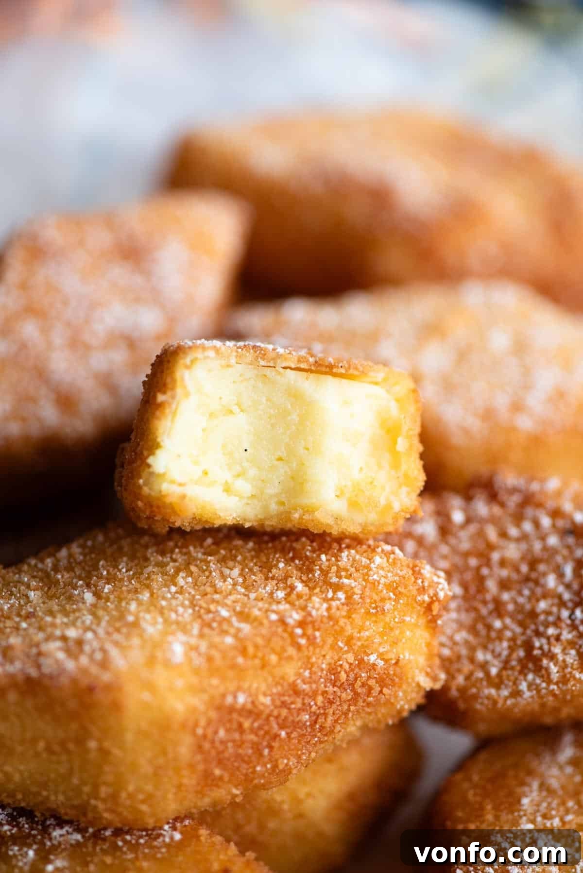 Golden Custard Fritters 8 A close up of Crema Fritta (deep fried custard) cut in half showing the inside.