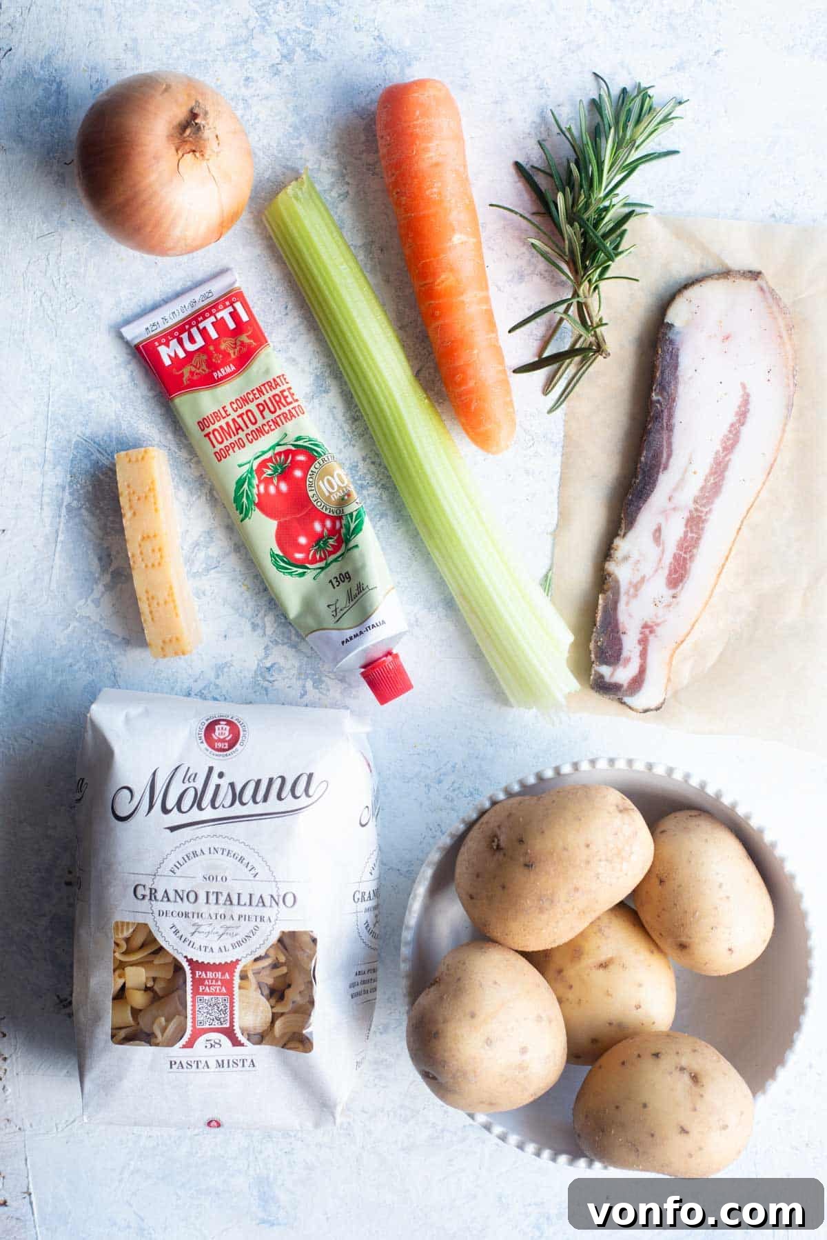 An overhead shot showcasing all the fresh and essential ingredients required to make authentic Pasta e Patate.