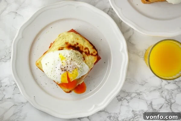 Four mouth-watering Croque Madame sandwiches displayed on a rustic wooden board, topped with golden cheese and soft poached eggs, ready to be served.