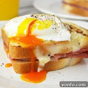 Close-up of a finished Croque Madame with a perfectly poached egg and golden cheese sauce.