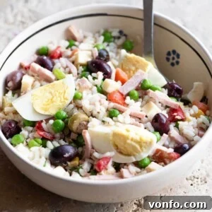 Refreshing Italian Rice Salad 6 A cropped square image of an Italian rice salad in a bowl, garnished with hard-boiled eggs.