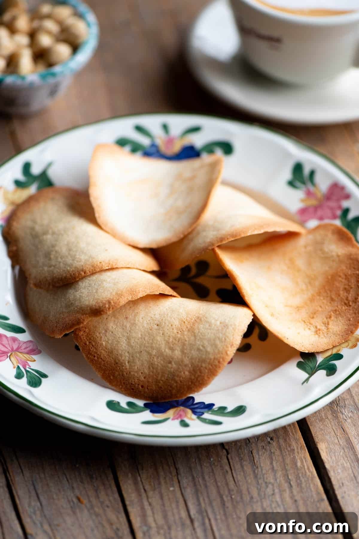 Delicious Tegole Valdostane cookies arranged on a plate, with a steaming cappuccino nearby, ready for a delightful pairing.
