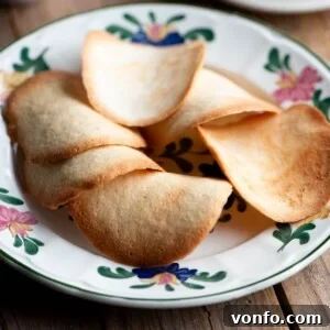 A close-up of Tegole Valdostane (Italian cookies) on a plate, highlighting their delicate, curved shape.
