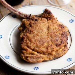 A cropped image of an Italian breaded veal chop on a plate.