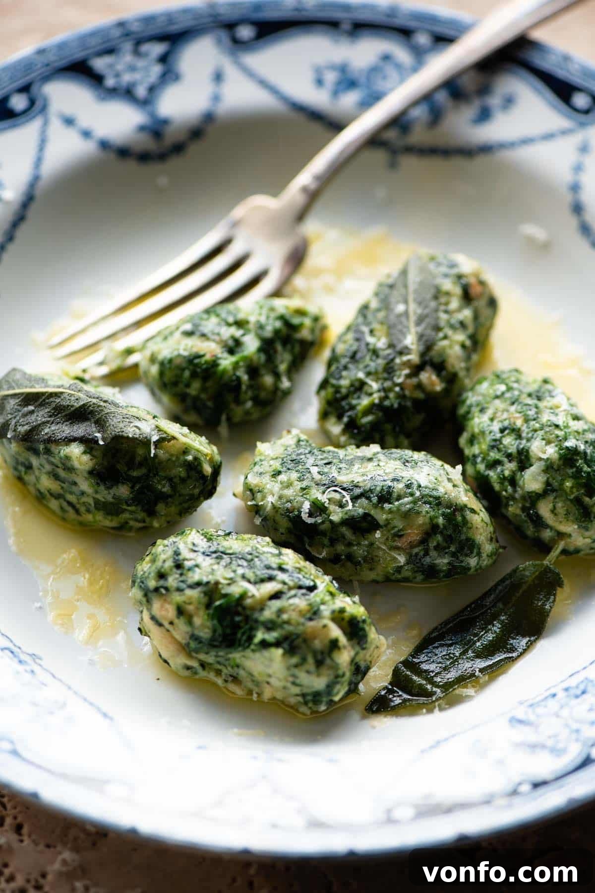 Strangolapreti: Priest Strangler Bread and Spinach Dumplings 8 A side shot of Strangolapreti (italian bread dumplings) on a plate with butter and sage.