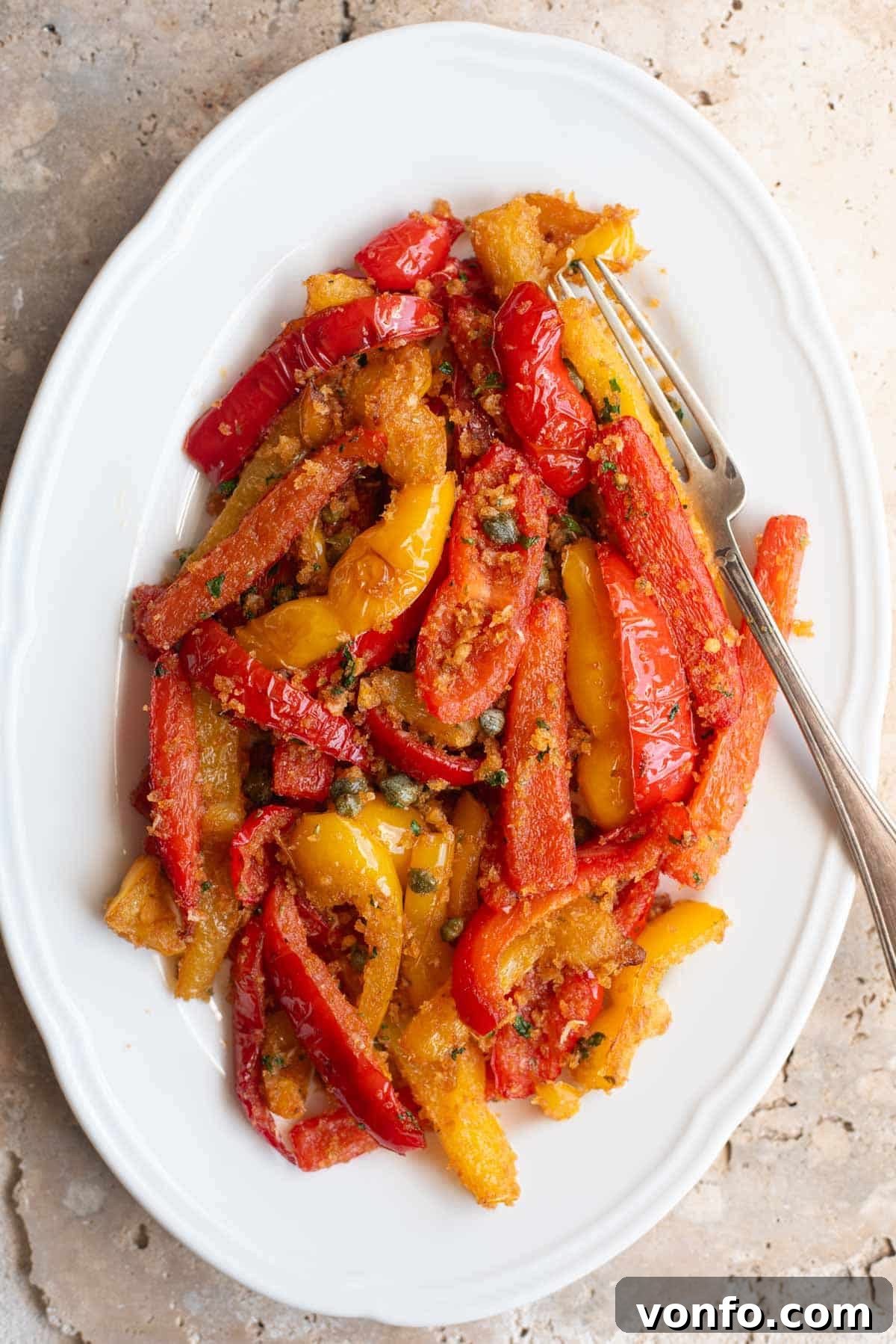 Rustic Peppers and Crispy Breadcrumbs 2 An overhead shot of Peperoni Ammollicati (Italian peppers and breadcrumbs) on a white serving plate, showcasing the vibrant colors of the peppers and golden breadcrumbs.