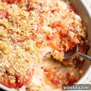A close up cropped image of an Italian potato and tomato gratin, Patate alla Lucana, showcasing its rich golden-brown topping and tender layers.