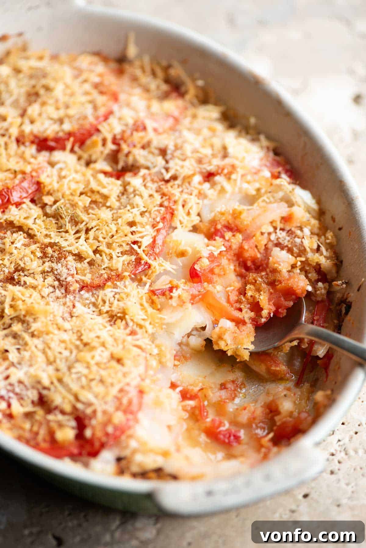 Southern Italian Potato Gratin 7 A side shot of the delicious Patate alla Lucana gratin, showcasing its golden-brown crust and layers of potatoes and tomatoes within an oval baking dish.