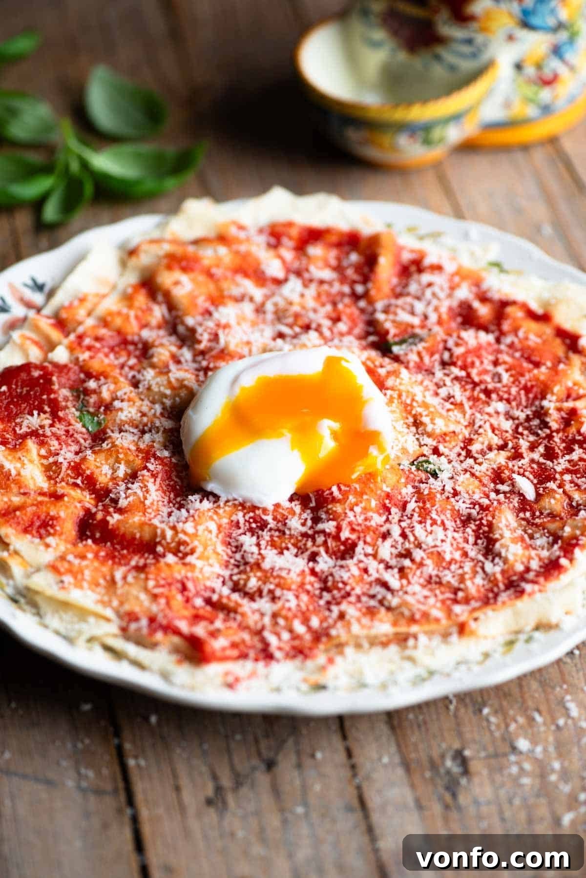 A vibrant plate of Pane Frattau, showcasing layers of tomato-soaked bread topped with a perfectly poached egg, with a rustic Sardinian aesthetic.