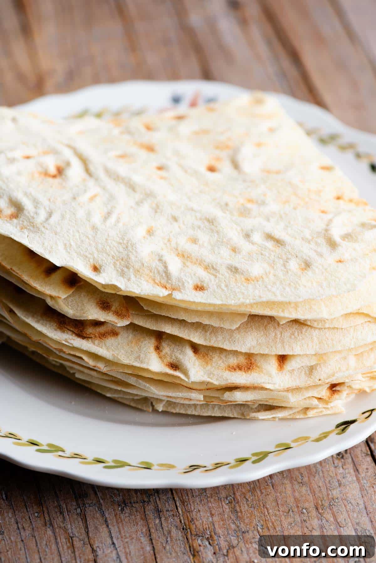 A close-up shot of stacks of Pane Carasau, highlighting its remarkably thin, crisp texture and iconic round appearance, ready for rehydration.