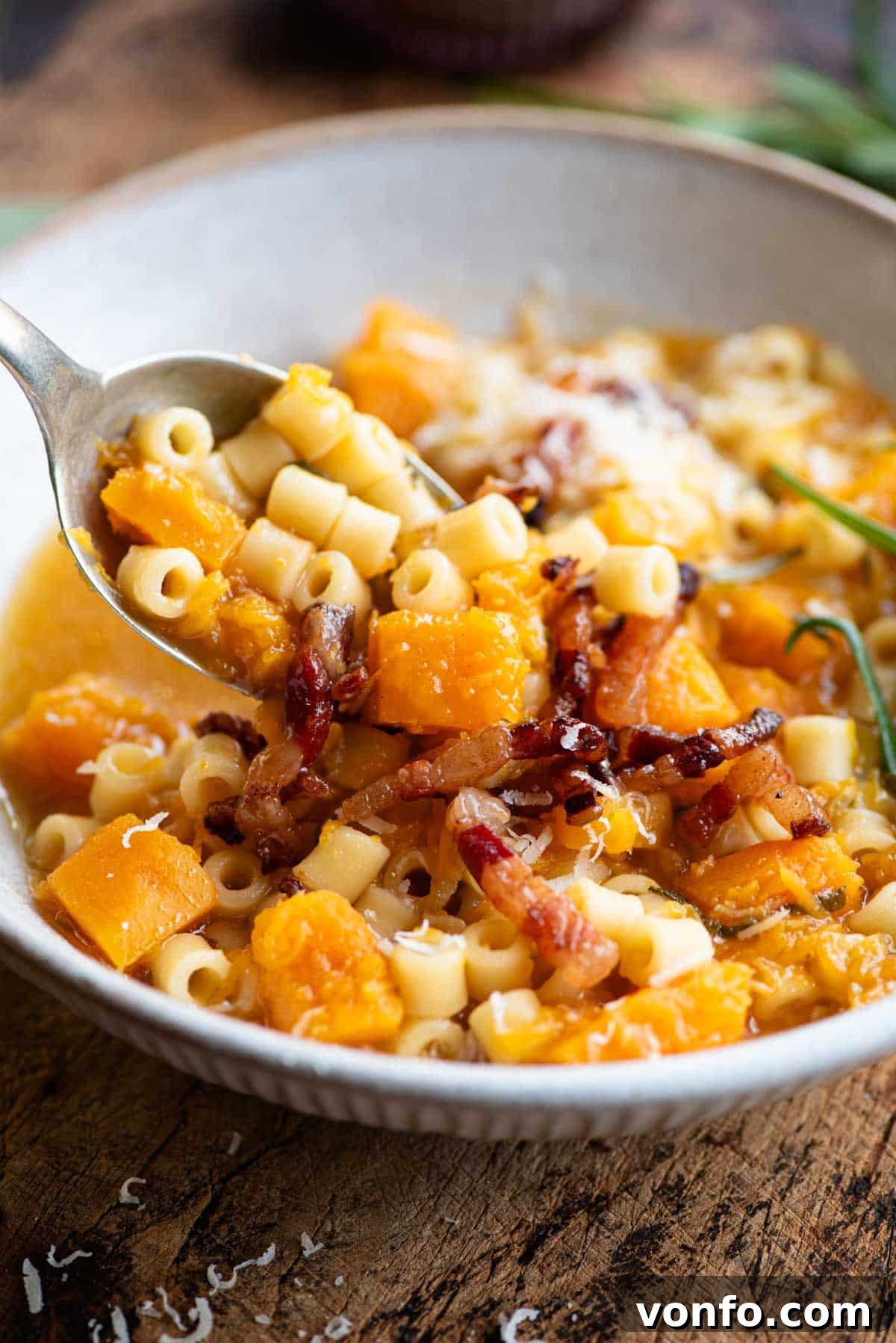 Golden Butternut Pasta Soup with Crispy Pancetta 6 A close up of a spoonful of butternut squash and pasta soup.