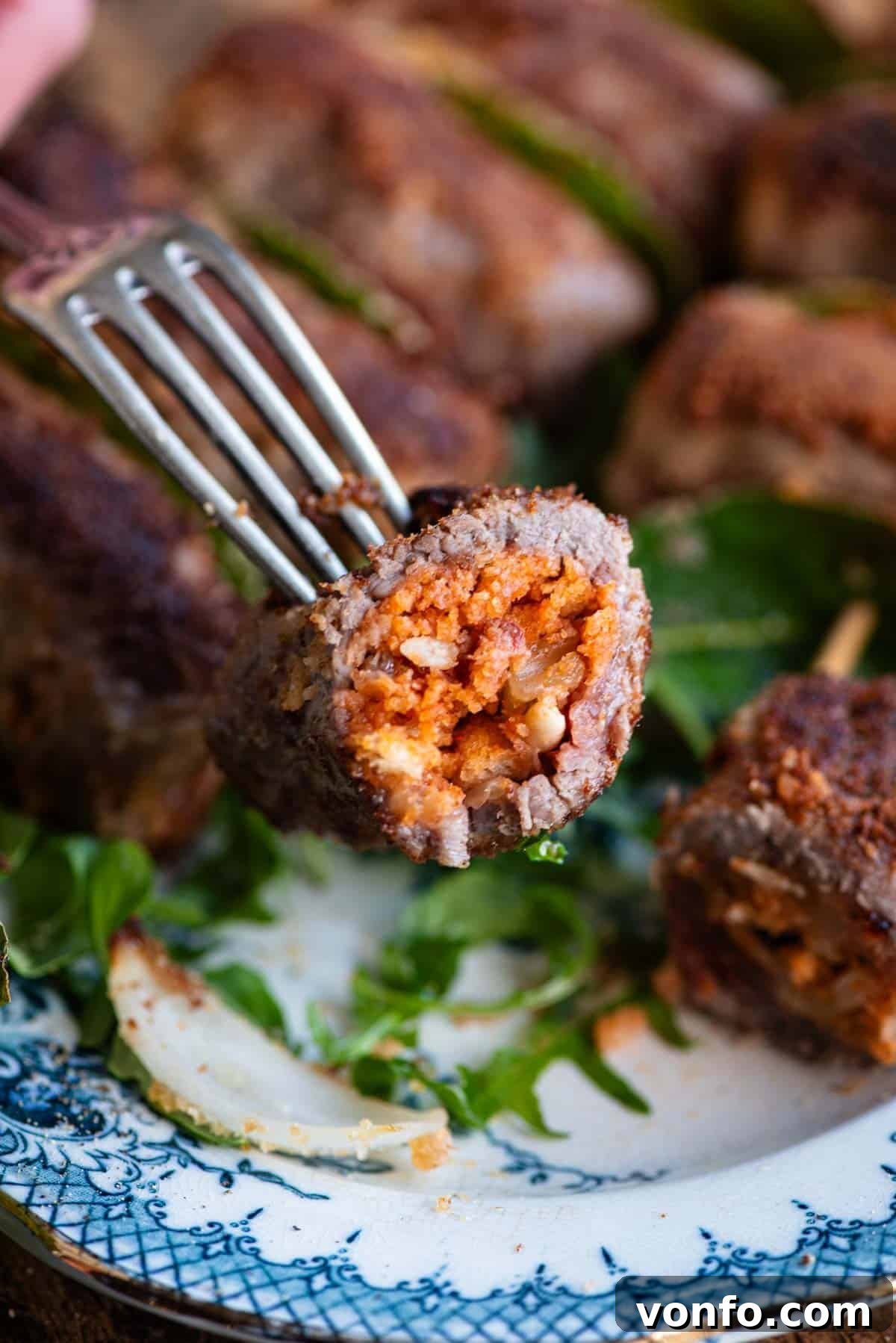 Palermo Style Beef Rolls 8 A close up of one Sicilian stuffed beef roll cut in half on a fork, revealing the delicious filling.