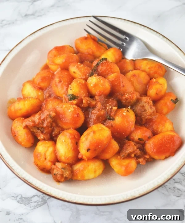 Close-up of fluffy gnocchi coated in a rich, flavorful 'Nduja tomato sauce, promising a deeply satisfying meal.