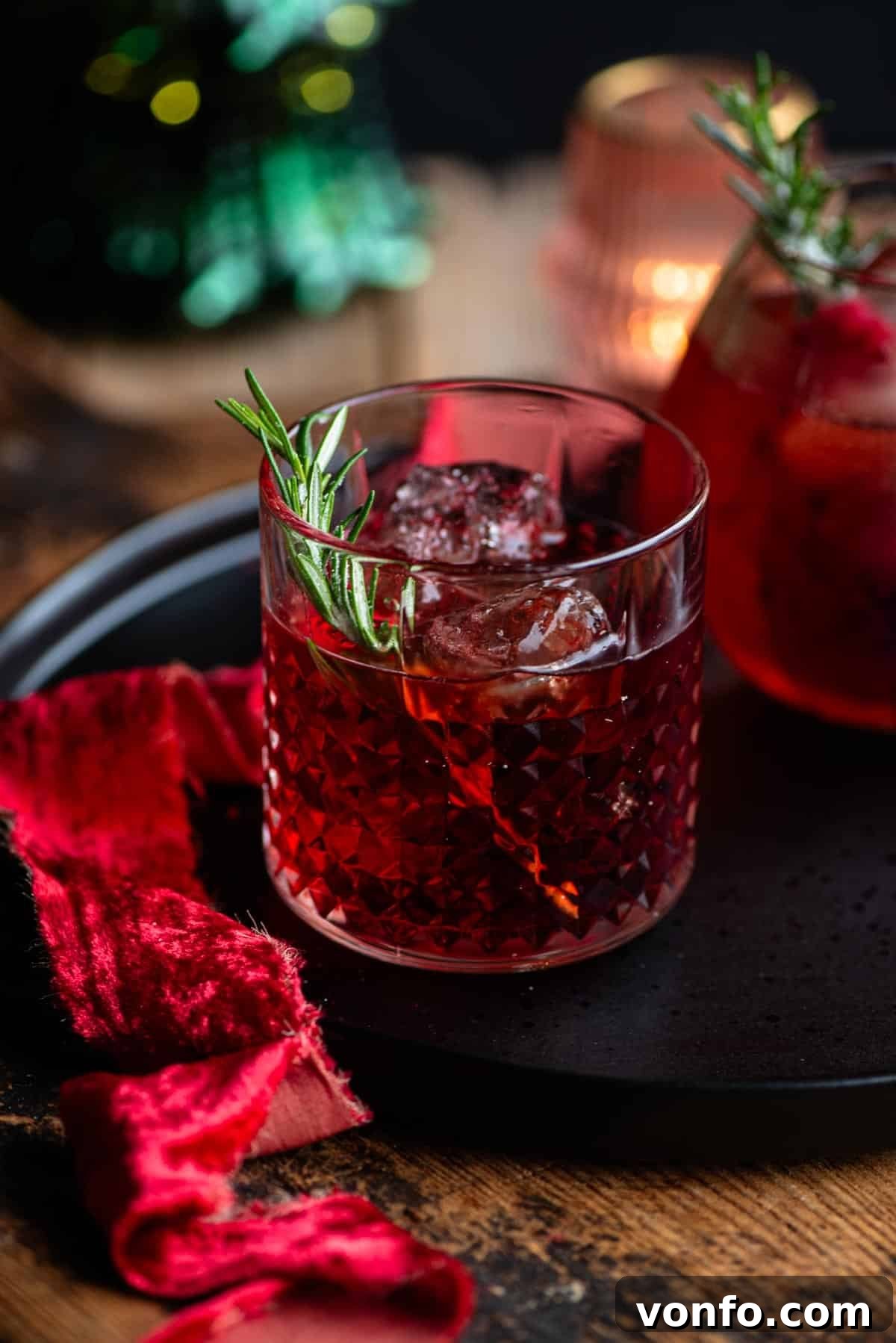 A red Sbagliato Rosso cocktail in a class with a sprig of rosemary, showcasing its vibrant color and fresh garnish.