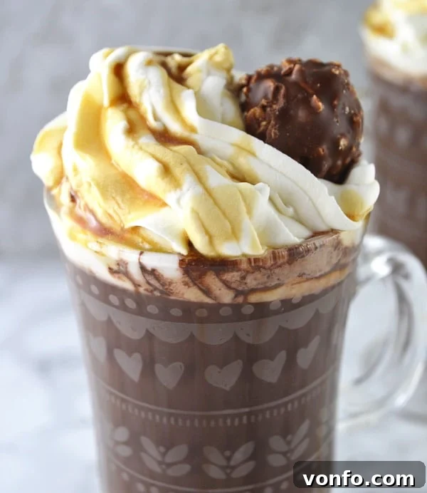 Two mugs of Baileys Hot Chocolate with Maple Whipped Cream, ready to be enjoyed, exuding warmth and festive spirit.