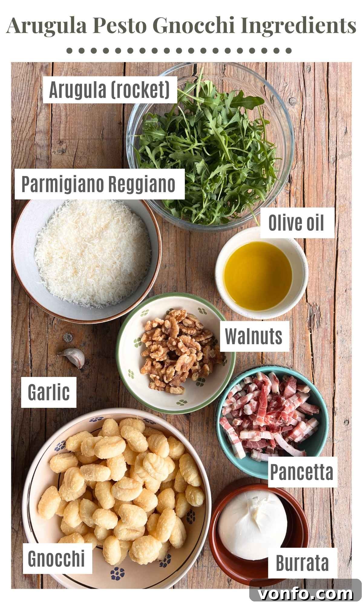 An overhead shot displaying all the fresh, high-quality ingredients needed to prepare gnocchi with arugula pesto, crispy pancetta, and creamy burrata.