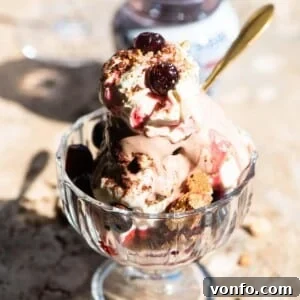 A close up of an Italian ice cream sundae in a glass jar topped with whipped cream and amarena cherries.