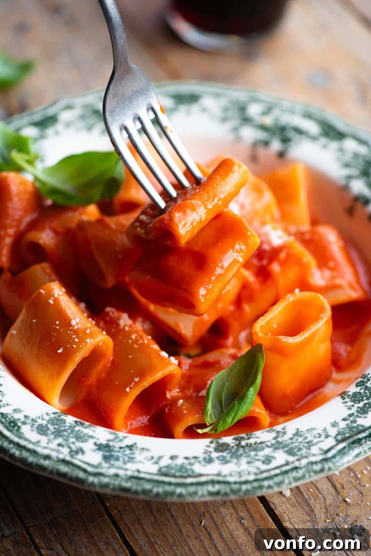 A collage of two photos showing the final steps: transferring cooked pasta to the sauce, adding butter and cheese, and the finished dish served in a bowl with basil.