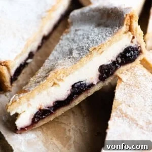 A close up of a a slice of ricotta and cherry tart.