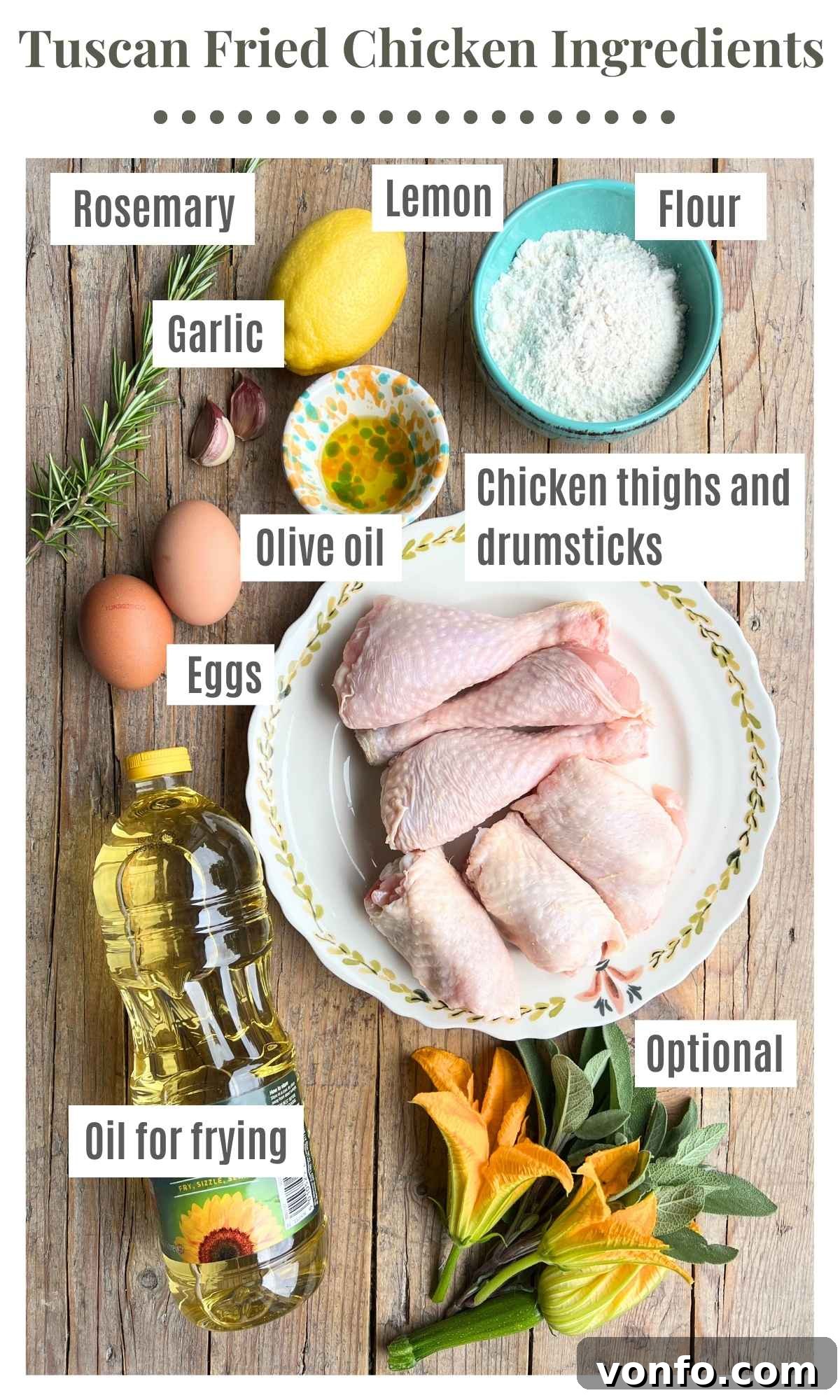 Rustic Tuscan Fried Chicken 3 A vibrant flat lay of all the fresh ingredients needed for Tuscan fried chicken, including raw chicken pieces, fresh rosemary, whole lemons, garlic cloves, and olive oil, arranged on a rustic wooden surface.