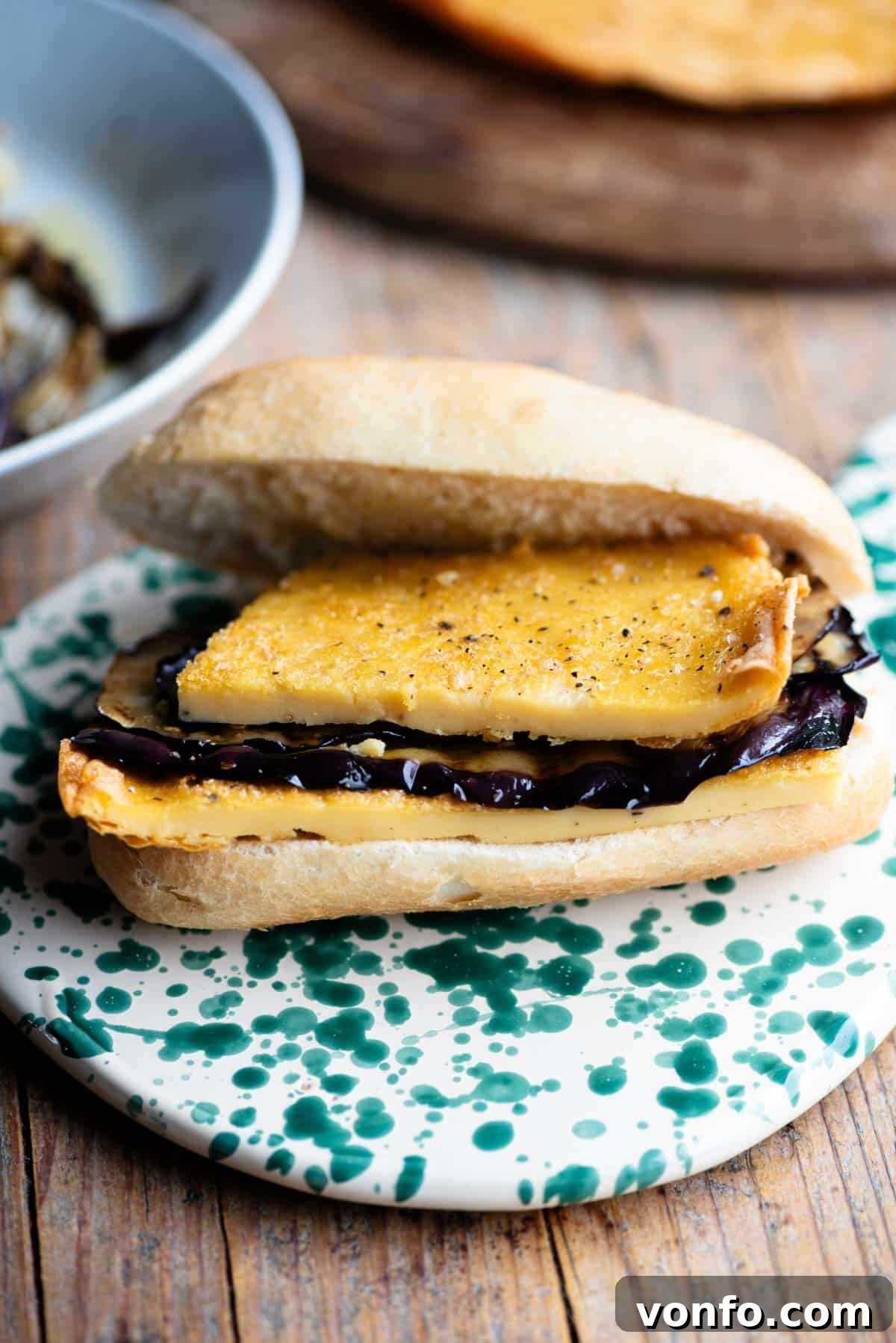 Cinque e Cinque: Livorno's Chickpea Pancake Sandwich 7 An open view of a 5x5 sandwich, revealing the thick, golden chickpea flatbread and the tender, marinated eggplant slices within the crusty roll.