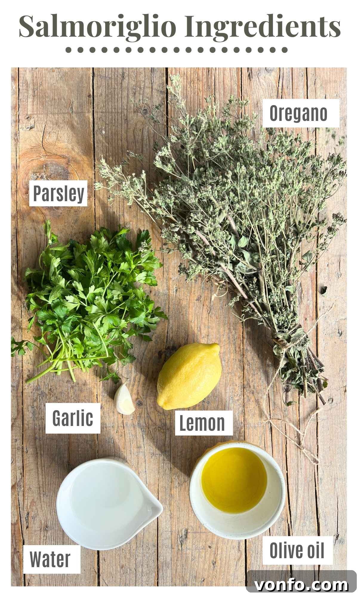 Dried oregano, fresh parsley, extra virgin olive oil, lemon, fresh garlic, and water artfully arranged on a rustic wooden surface.