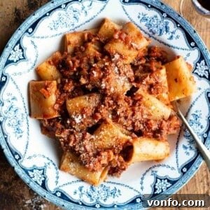 A close-up of hazelnut ragu and paccheri pasta in a blue and white vintage style bowl.