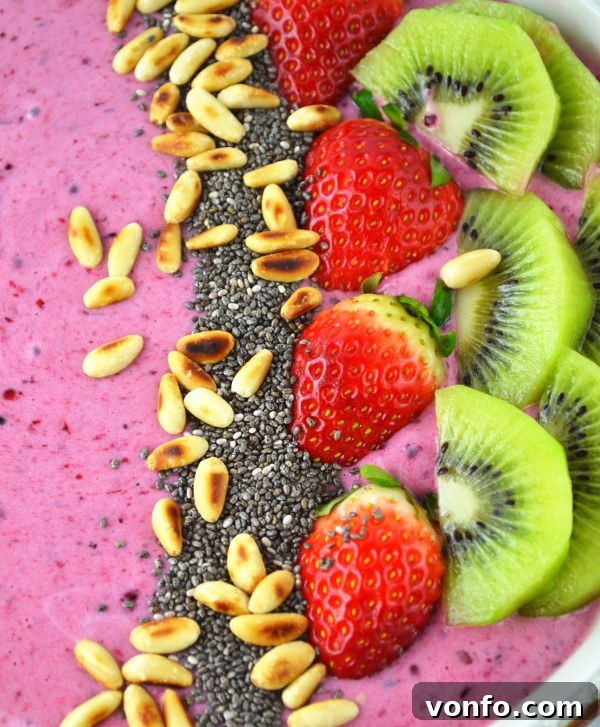 Close-up of Berry Banana Smoothie Bowl with layered fruit, chia seeds, and pine nuts