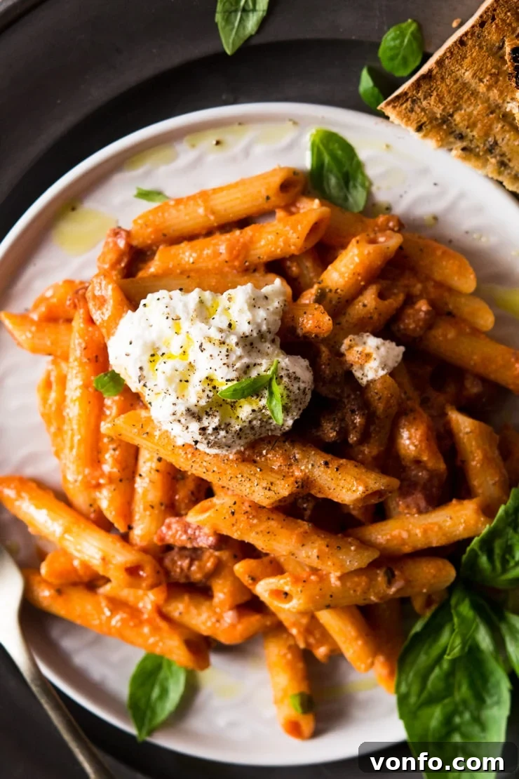 A close up of pasta with pancetta topped with a dollop of ricotta cheese A close-up shot of creamy penne pasta with crispy pancetta, topped with a luscious dollop of fresh ricotta cheese and a sprinkle of black pepper.