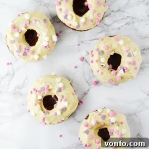 A close-up of a baked carrot cake doughnut with maple frosting on a wire rack. www.insidetherustickitchen.com