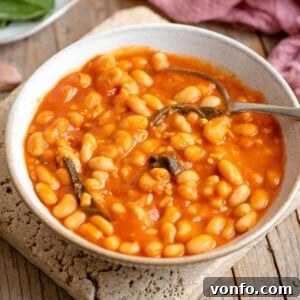 Tuscan White Beans in Rich Tomato Sauce 6 A bowl of creamy Tuscan beans in tomato sauce with sage leaves, ready to be served.