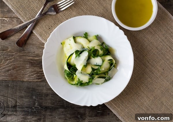 Serving Zucchini Ribbon Salad with lemon dressing in a bowl, showing the light and fresh texture. A perfect healthy side dish from insidetherustickitchen.com
