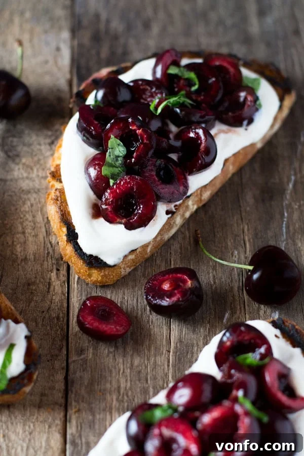 Balsamic Cherry Ricotta Toast 4 Close-up of whipped ricotta toast topped with balsamic cherries and fresh basil leaves, ready to be served.