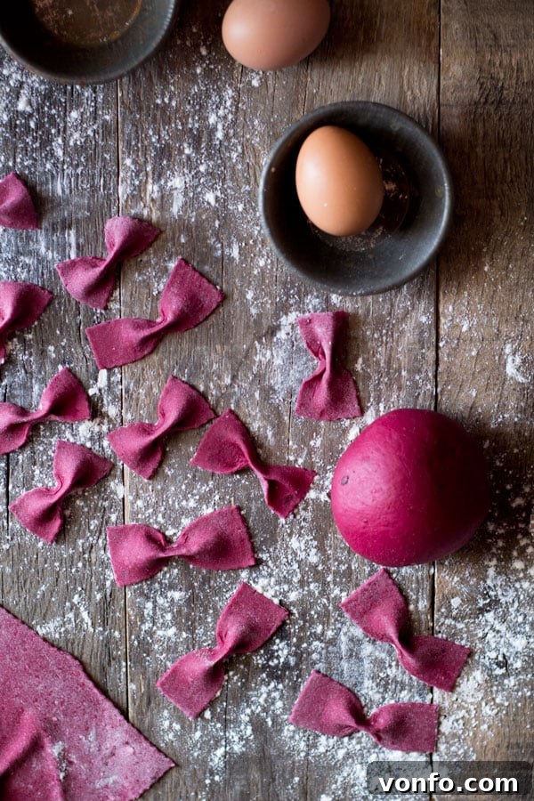 Hands rolling out beetroot pasta dough