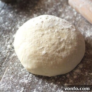 A ball of yeast free pizza dough on a wooden surface