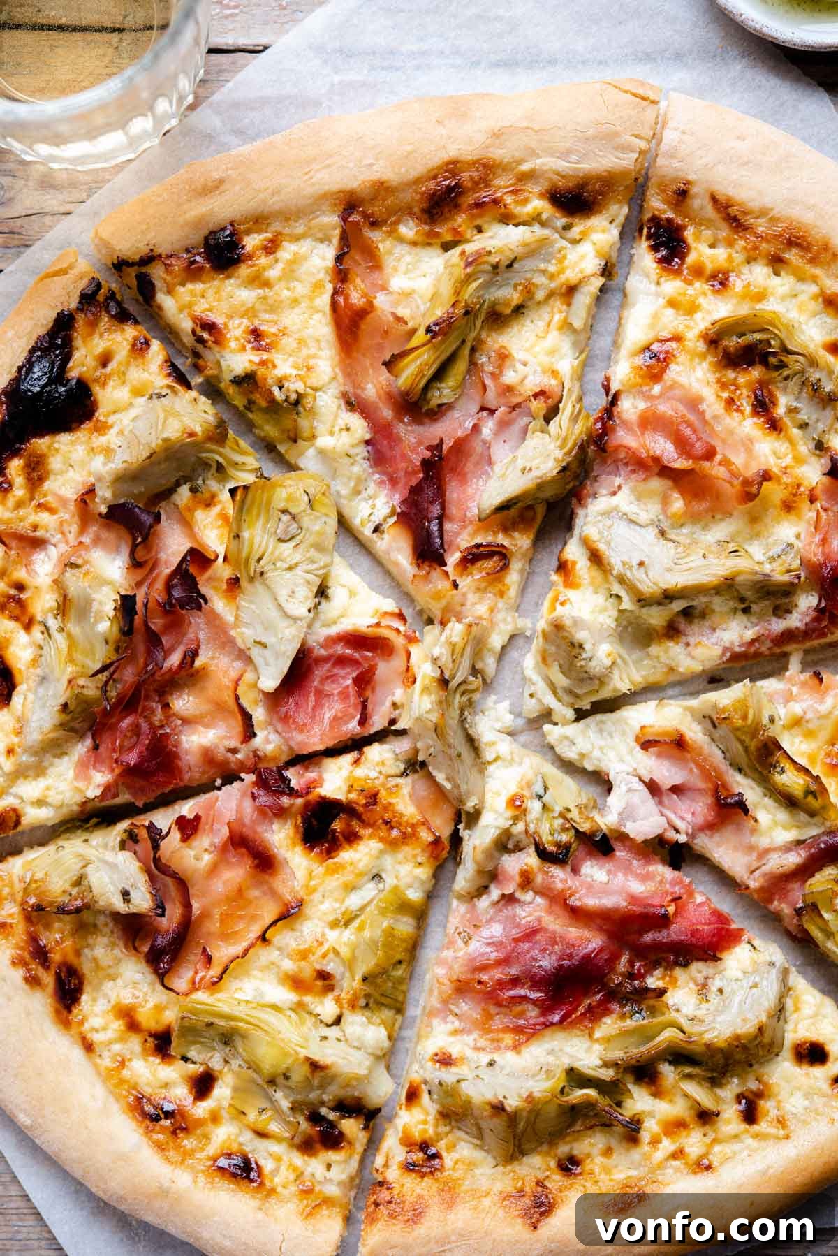 A close-up shot of a single slice of artichoke pizza with prosciutto cotto, showcasing the perfect melt of cheese and the vibrant toppings, ready to be enjoyed.