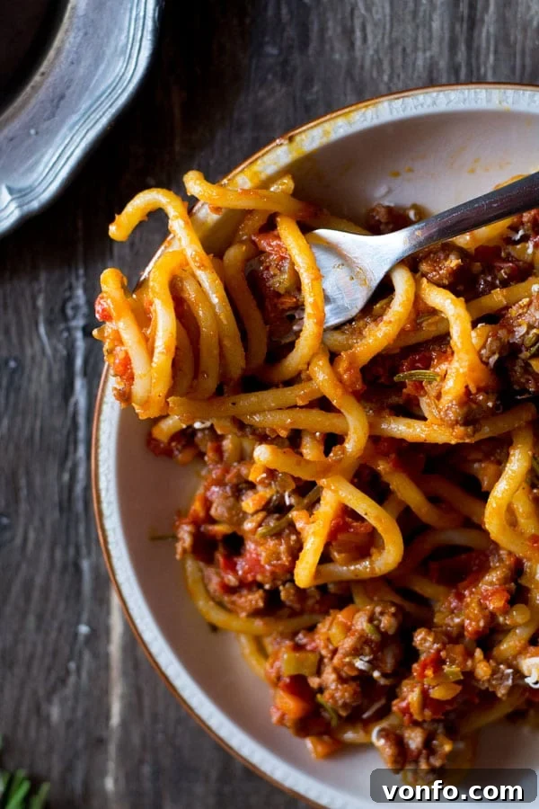 A flavor-packed Tuscan Sausage Ragu, an easy Italian recipe ideal for make-ahead weeknight or weekend meals. Find more authentic Italian pasta recipes at Inside the Rustic Kitchen. Pici Pasta tossed with Tuscan Sausage Ragu in a large bowl, ready to be served in a rustic kitchen setting.