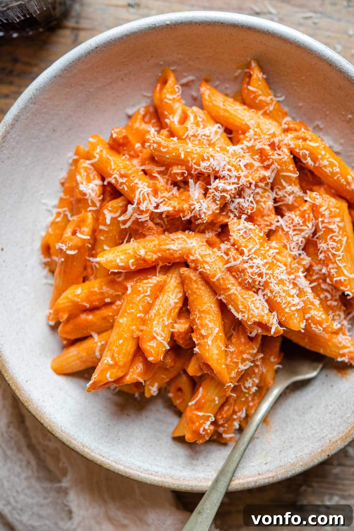 A close-up shot of Penne alla Vodka served in a rustic bowl, highlighting the texture of the pasta and the rich sauce.