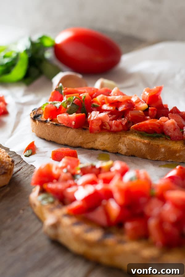 Chopped Tomatoes and Basil on Garlic Bruschetta A close-up view of freshly chopped, vibrant red tomatoes and green basil atop crispy, toasted garlic bread, presented on a rustic wooden board.
