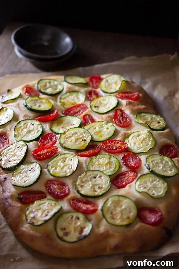 Authentic Zucchini Tomato Focaccia Recipe: A Taste of Italian Summer Freshly baked Zucchini Tomato Focaccia cooling on a wire rack, showing its soft interior and crispy crust.