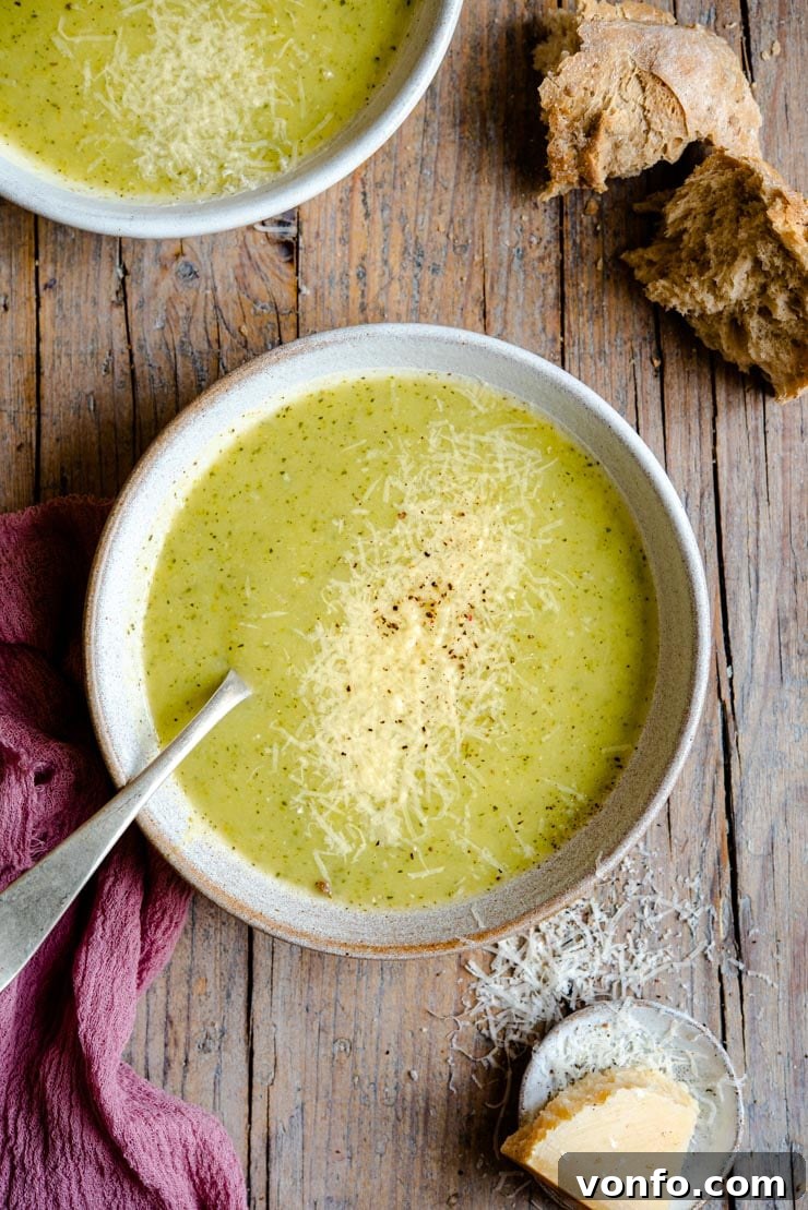 Creamy Italian Potato and Zucchini Soup - An easy soup that's comforting, warming and packed full of flavour. Healthy, delicious and easy comfort food the whole family will love. #zucchini #soup #comfortfood An overhead shot of creamy zucchini soup in two bowl with crusty bread at the side