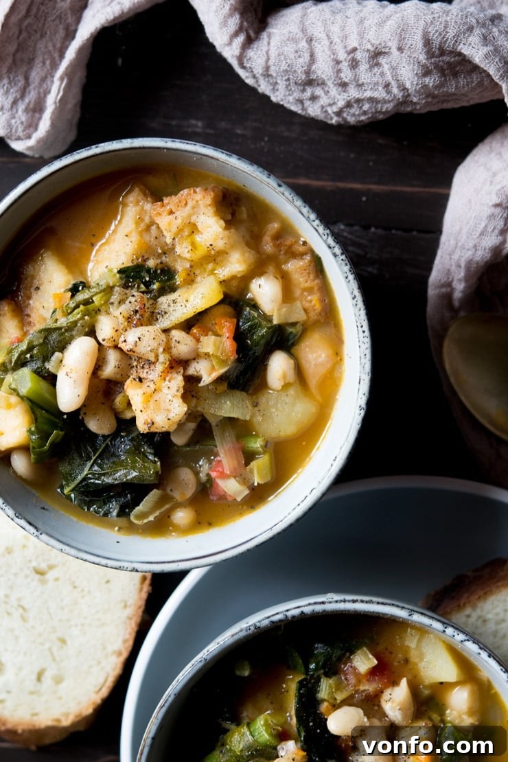 Ribollita Served Overhead shot of a rich and hearty Ribollita Tuscan vegetable stew with crusty bread in the background
