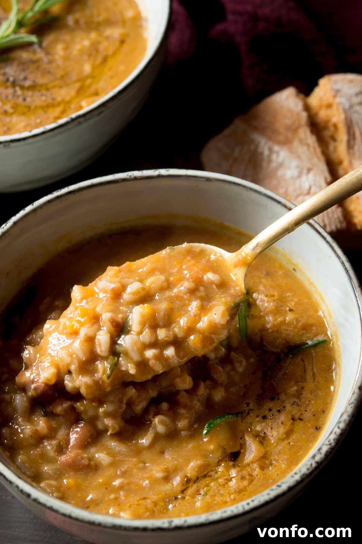 Hearty Tuscan Farro and Bean Soup 5 A close-up shot of a spoonful of creamy Tuscan farro soup, highlighting the tender farro grains, beans, and rich broth, ready to be savored.