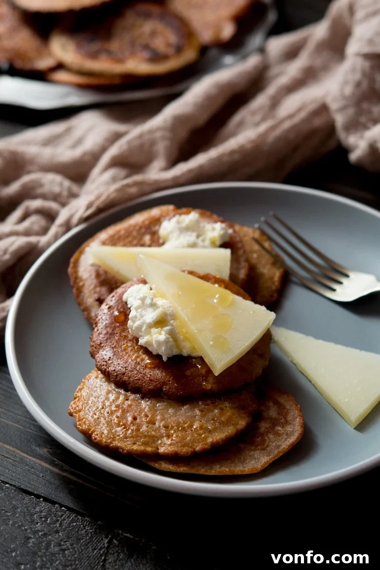 Chestnut Fritters with Ricotta, Pecorino, and Truffle Honey on a Blue Plate Golden-brown chestnut fritters topped with creamy ricotta, delicate slices of pecorino cheese, and a glossy drizzle of truffle honey, arranged artfully on a blue plate, ready to be enjoyed as a delightful autumn treat.