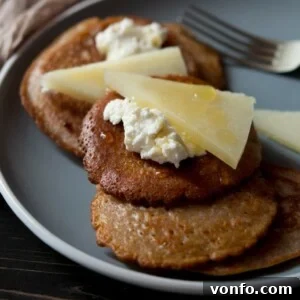 Golden Chestnut Fritters with Creamy Ricotta, Sharp Pecorino, and Truffle Honey 2 A small plate of golden-brown chestnut fritters, glistening with truffle honey, and topped with creamy ricotta and shaved pecorino cheese, signifying a delicious, quick snack or dessert.