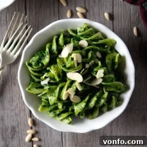 A beautifully presented bowl of fresh cavolo nero pesto pasta, garnished with almonds and ready to be enjoyed