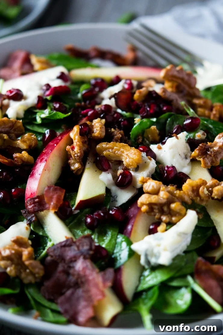 Close-up of Winter Salad Ingredients A close-up view of the winter salad, highlighting the vibrant colors of apple, spinach, pomegranate, and the creamy gorgonzola