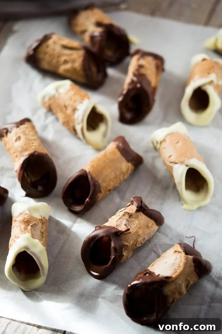Mini cannoli shells dipped in chocolate Mini cannoli shells dipped in chocolate, drying on parchment paper, ready for filling.
