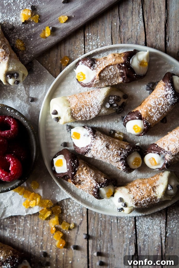 mini cannoli with orange and dark chocolate on a wooden surface Mini cannoli with candied orange and dark chocolate on a wooden surface, showcasing beautiful garnishes.